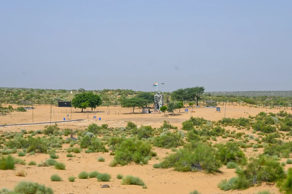 India–Pakistan border post in Jaisalmer desert with BSF watchtower, tricolor flag, and sparse Thar vegetation