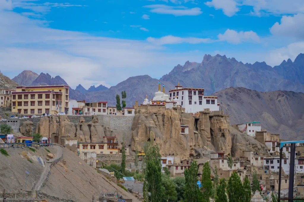 Lamayuru Monastery and surrounding Ladakhi village perched on dramatic rocky cliffs with mountains in the background.
