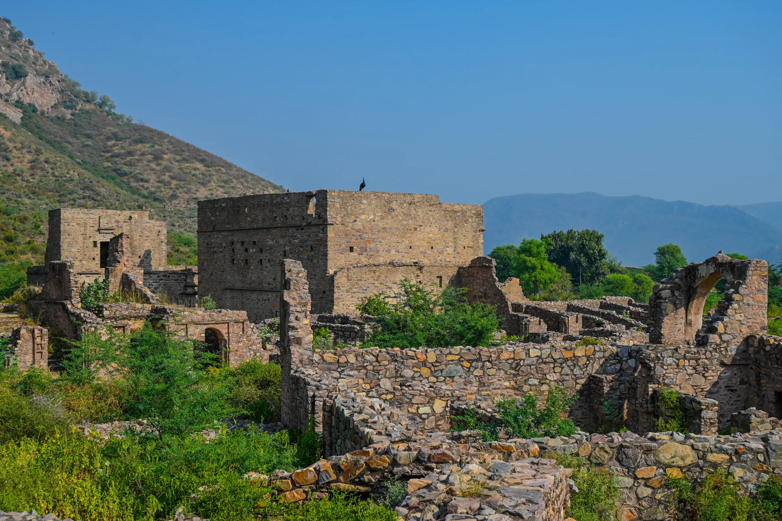 Central ruined structures of Bhangarh Fort in Alwar surrounded by scrub and hills in Rajasthan
