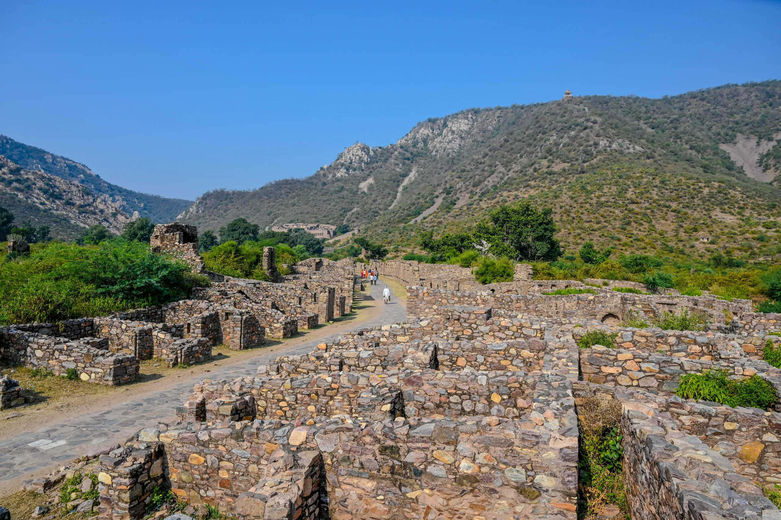 Visitors walking on the central pathway through Bhangarh Fort ruins in Alwar Rajasthan