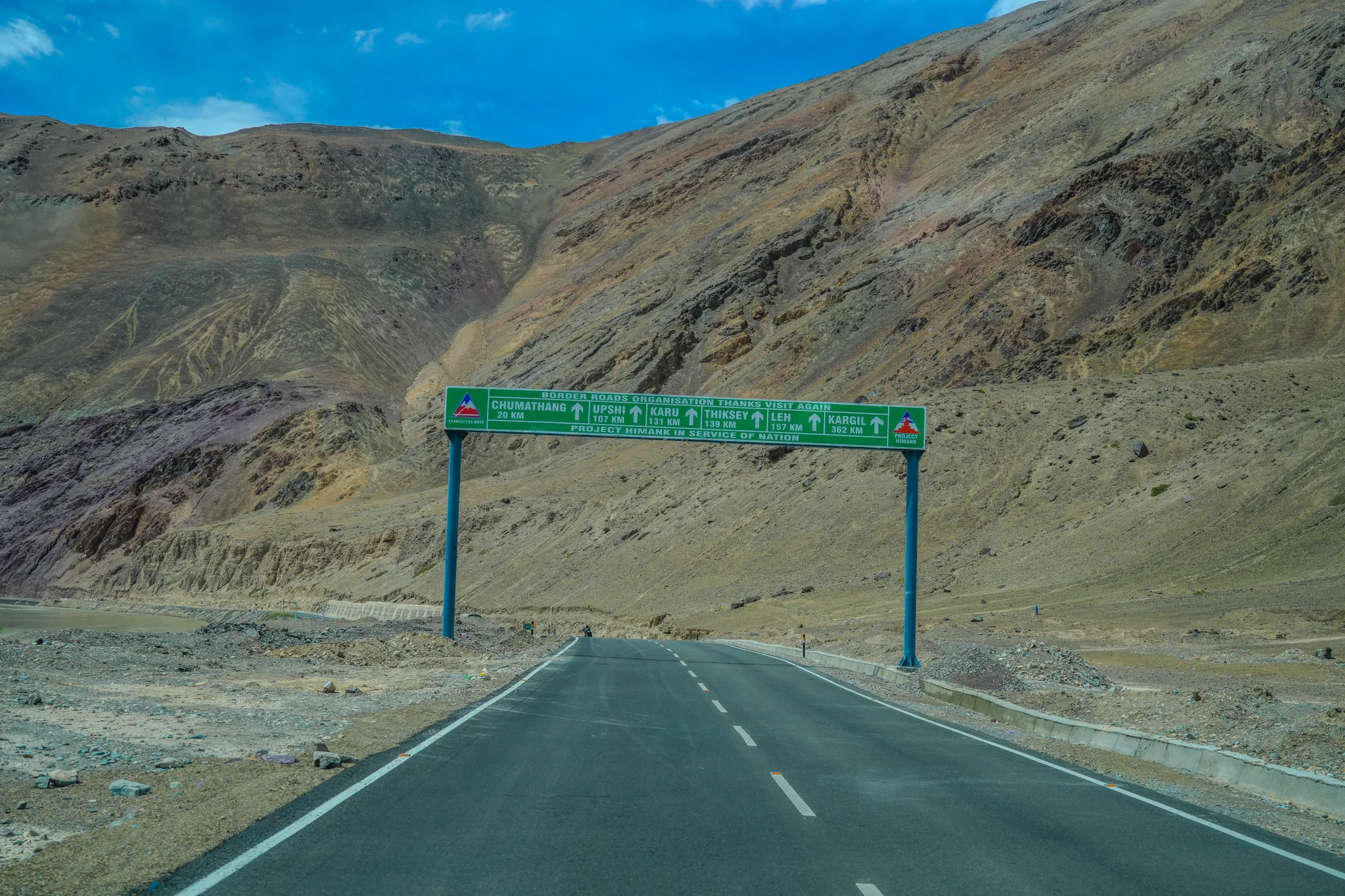 Leh road signboard pointing toward Chumathang, Karu, Thiksey, and Kargil